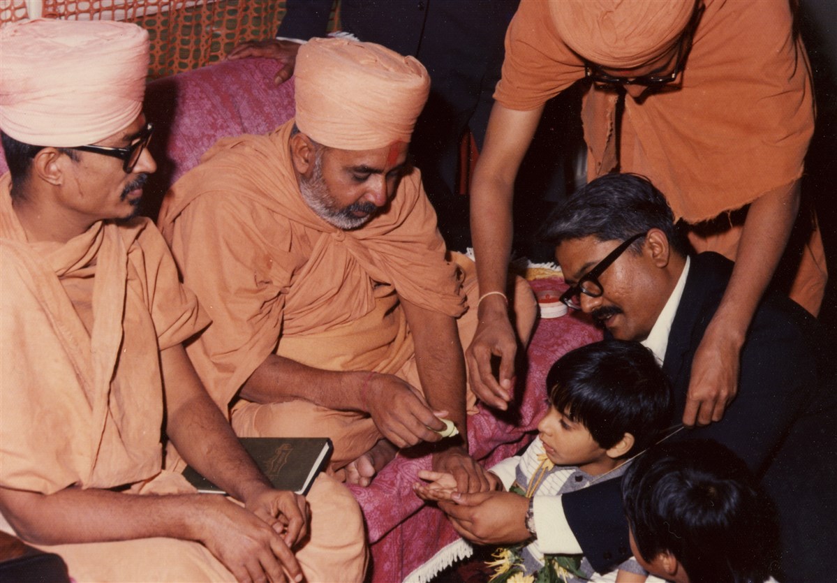 Pramukh Swami Maharaj initiating a new family into satsang during his visit in 1974