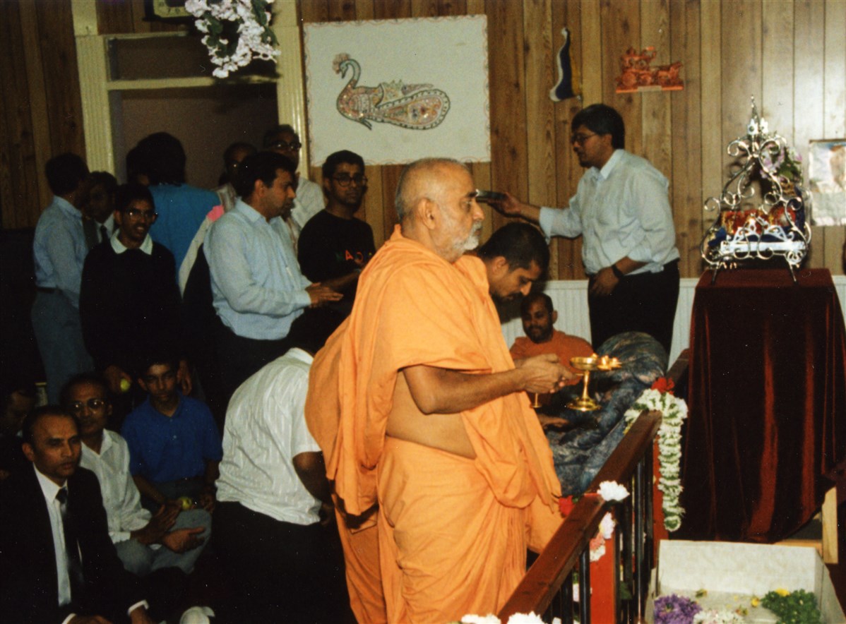 Pramukh Swami Maharaj performs the arti upon arriving at the hari mandir in 1990, his seventh visit to Ashton-under-Lyne
