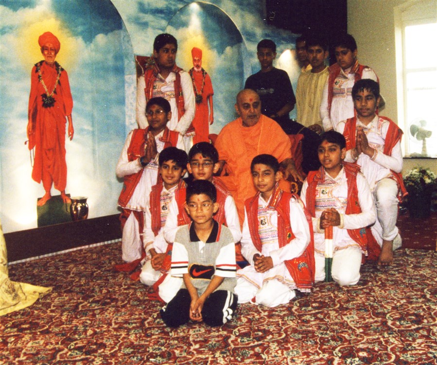 A troupe of children pose with Pramukh Swami Maharaj after a performance during his visit in 2000