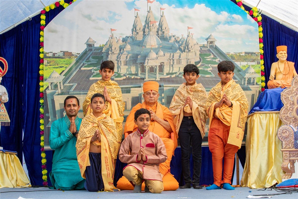 Children pose with Pujya Ishwarcharandas Swami after reciting verses from Satsang Diksha in Sanskrit and French
