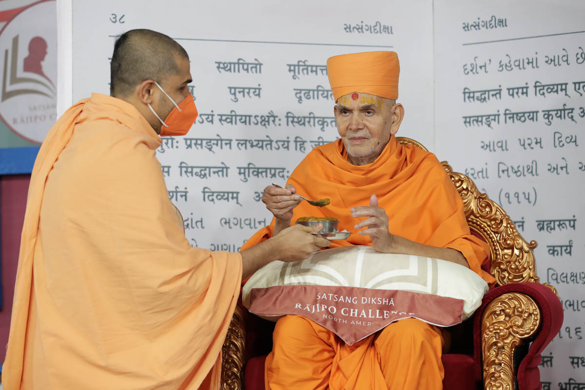 Swamishri offers prasad to devotees