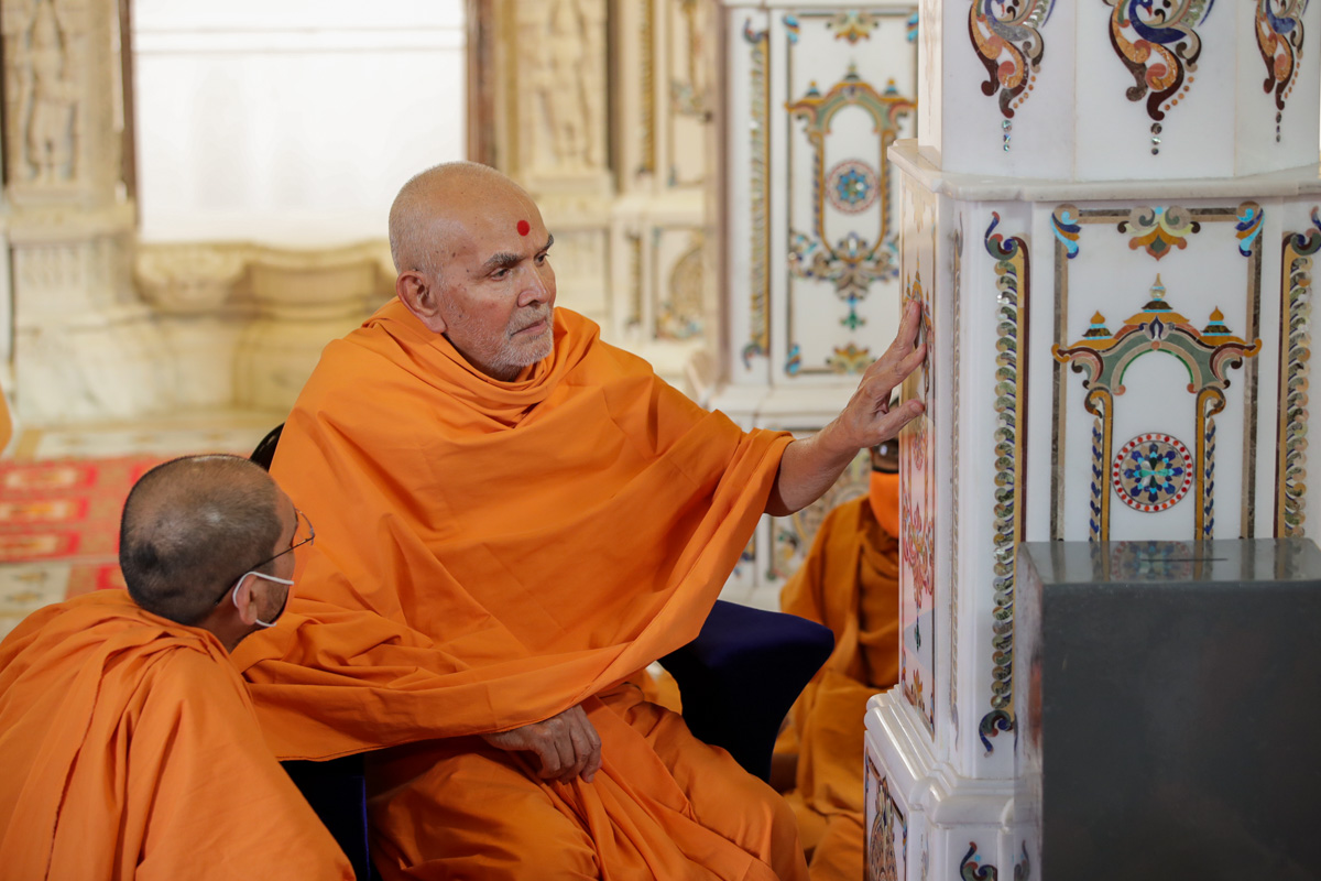 Swamishri observes designs on a pillar