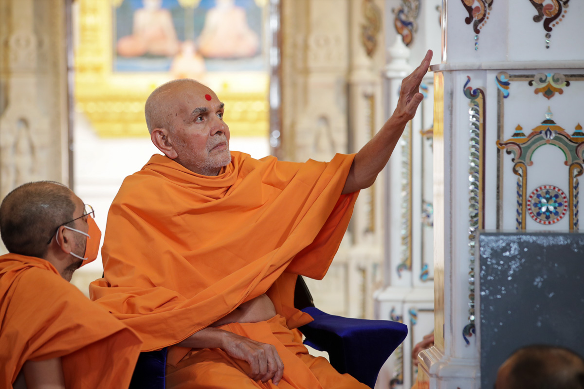 Swamishri observes designs on a pillar