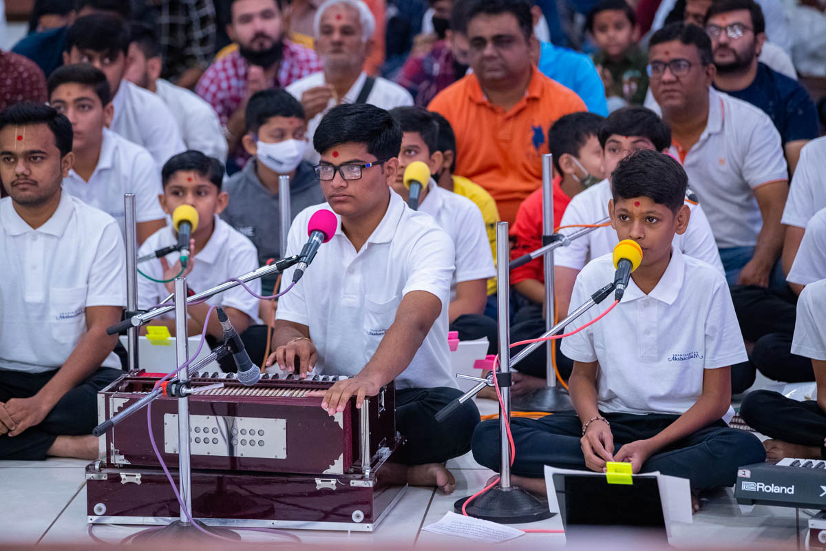 Students of Swaminarayan Vidyamandir, Gondal, sing kirtans in Swamishri's daily puja