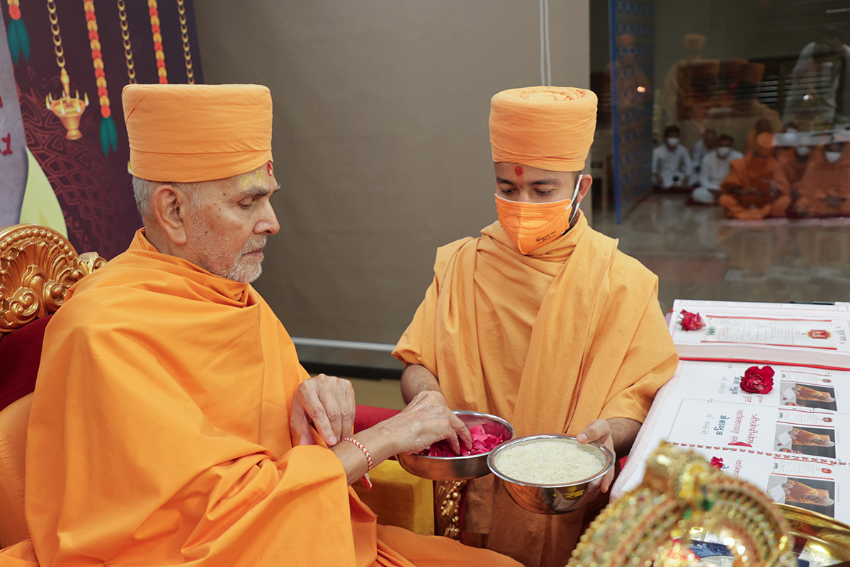 Swamishri sanctifies flower petals and rice grains