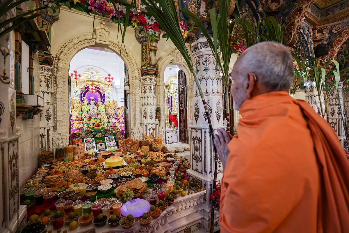 Swamishri doing darshan of annakut offered to Bhagwan Swaminarayan, Aksharbrahman Gunatitanand Swami and Shri Gopalanand Swami