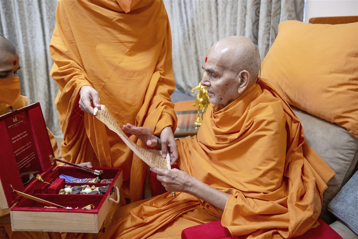 Mahant Swami Maharaj blessed a devotional gift box that contained a special invitation to bless the Mandir Mahotsav festivities