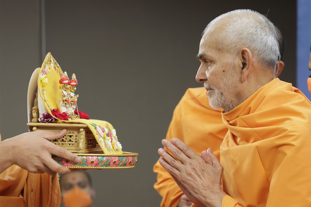 Param Pujya Mahant Swami Maharaj engrossed in darshan of Shri Harikrishna Maharaj and Shri Gunatitanand Swami