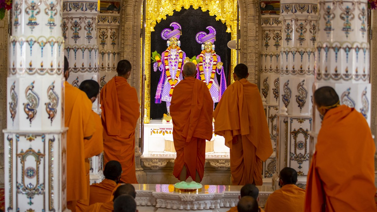 Swamishri and sadhus engrossed in darshan of Bhagwan Swaminarayan and Aksharbrahma Gunatitanand Swami