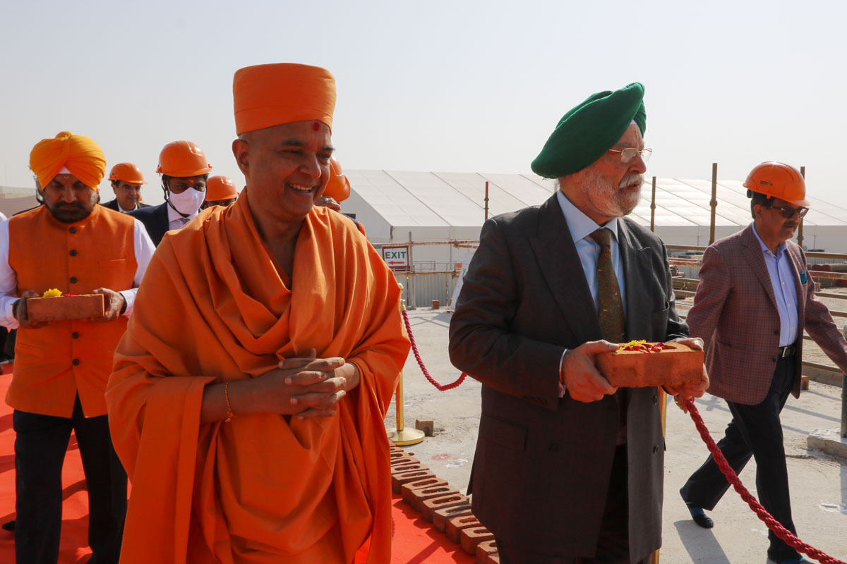 Honorable Minister personally carries sanctified brick to be placed