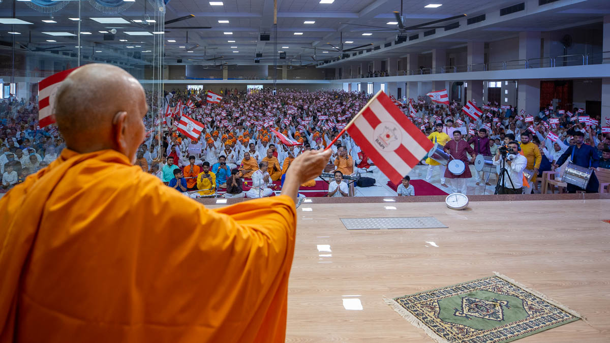 Swamishri and devotees wave BAPS flags