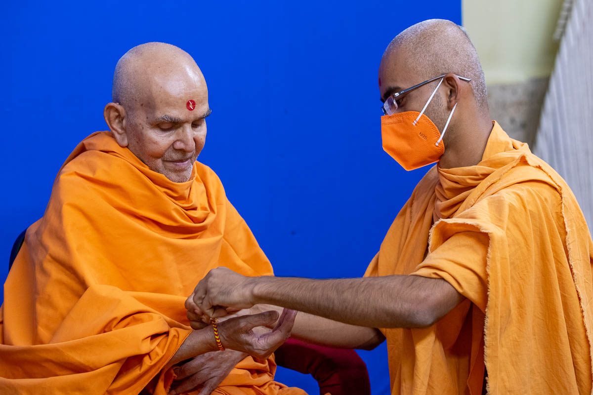 A sadhu ties a nadachhadi to Swamishri