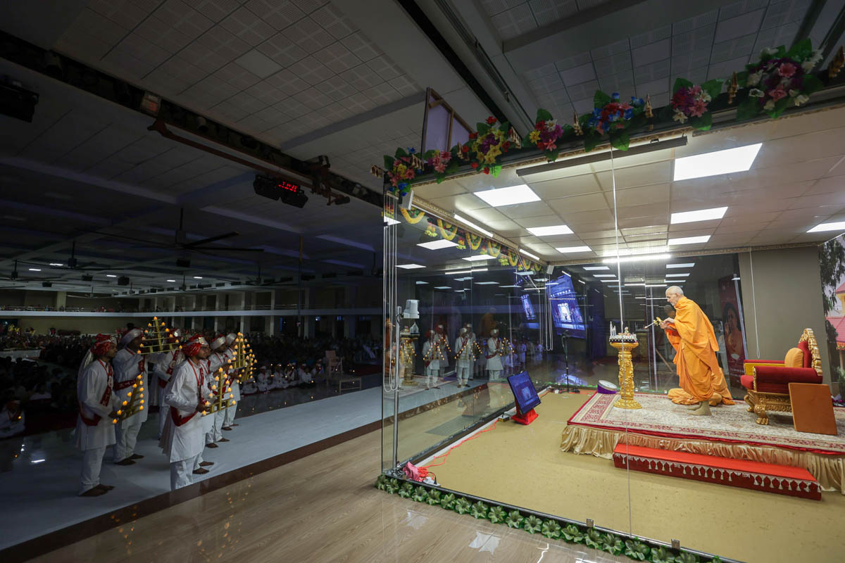 Swamishri and youths perform the arti