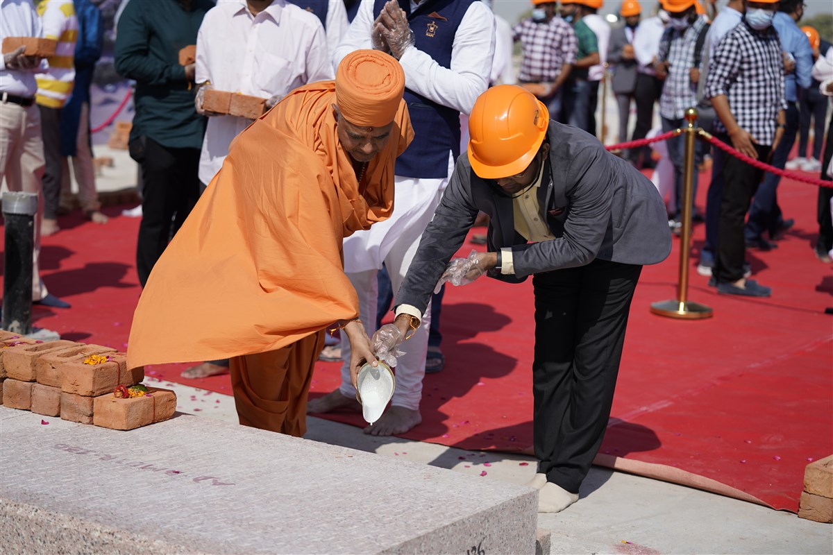 Guests and donors cement the first stone of the mandir