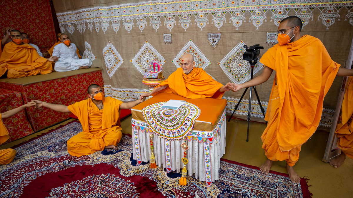 Swamishri joins hands with sadhus in a gesture of unity