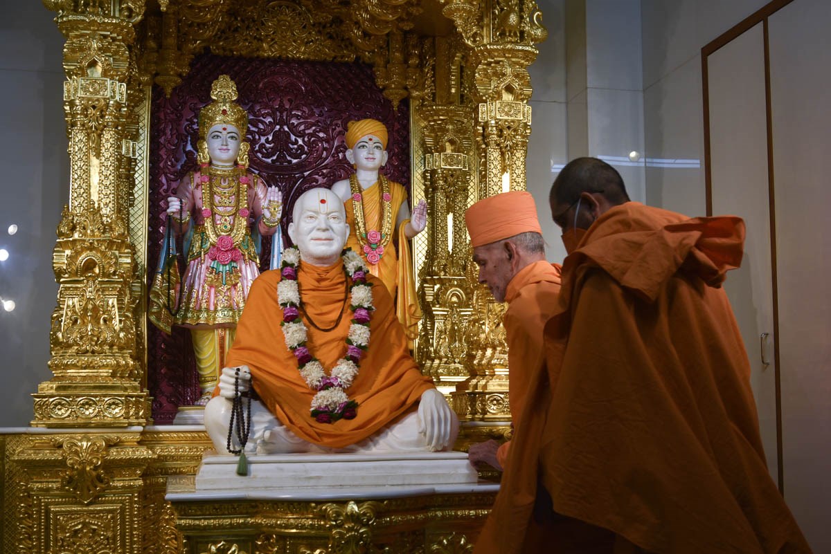 Swamishri engrossed in darshan of Shri Akshar-Purushottam Maharaj and Brahmaswarup Yogiji Maharaj