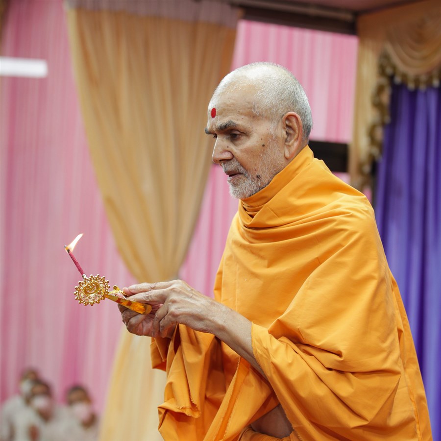 Swamishri performs the evening arti in the assembly hall