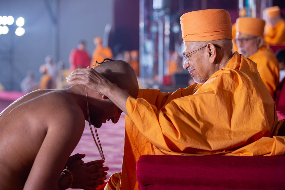 Pujya Tyagvallabh Swami places a kanthi on new initiates