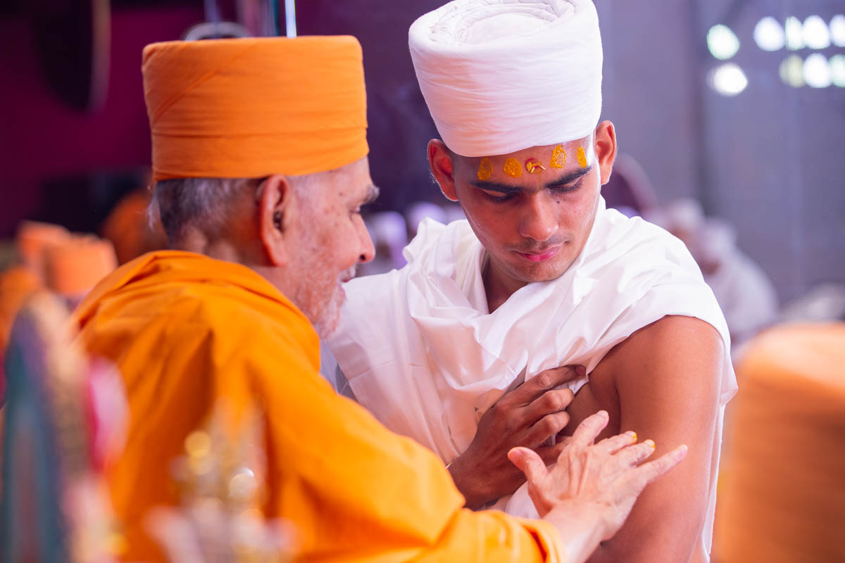 Swamishri gives diksha mantra and blessings to newly initiated parshads