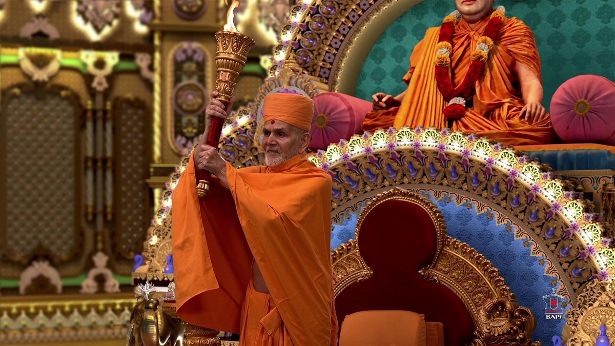 Swamishri holds a flame torch