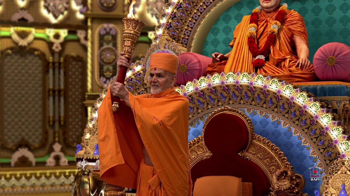 Swamishri holds a flame torch