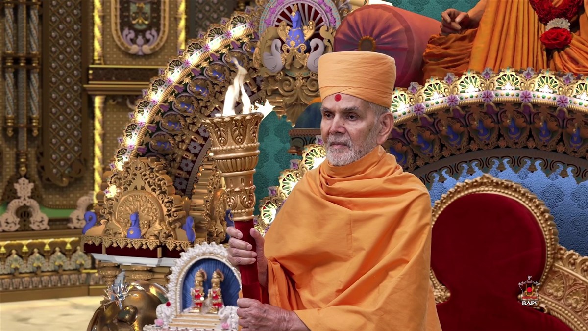 Swamishri holds a flame torch