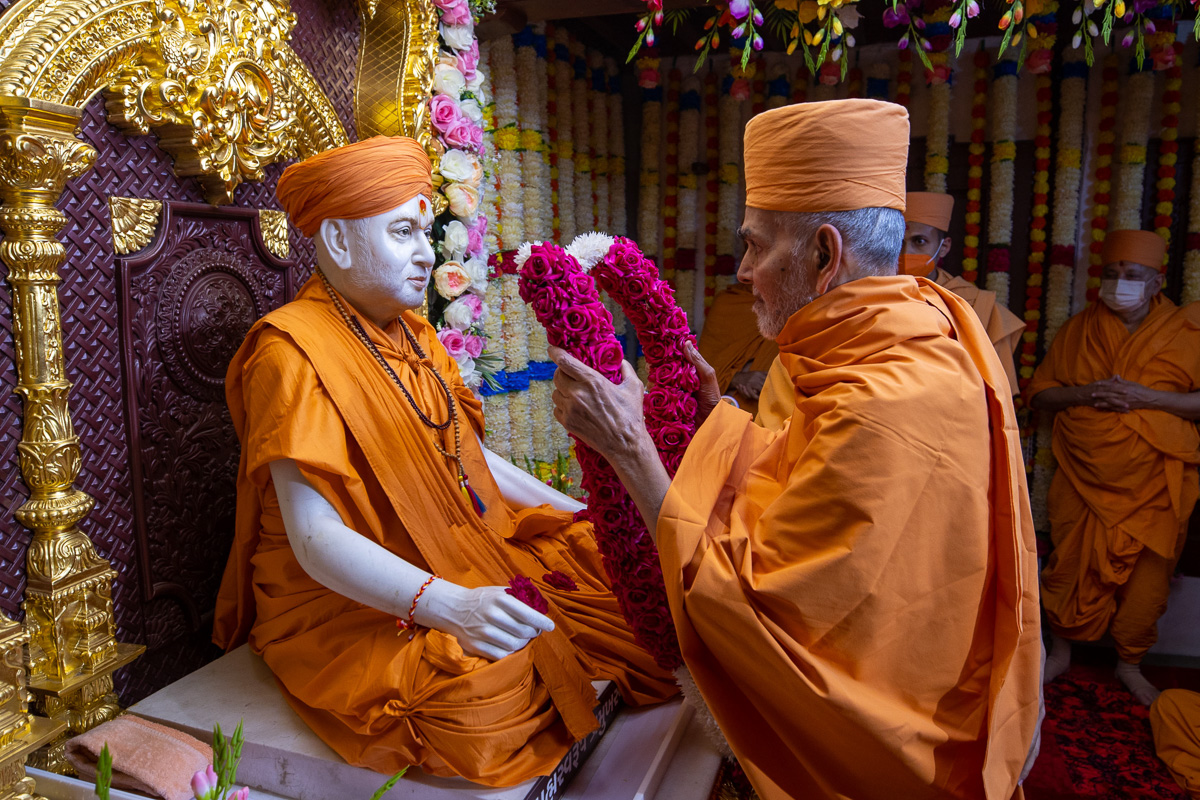 Swamishri honors Brahmaswarup Pramukh Swami Maharaj with a garland