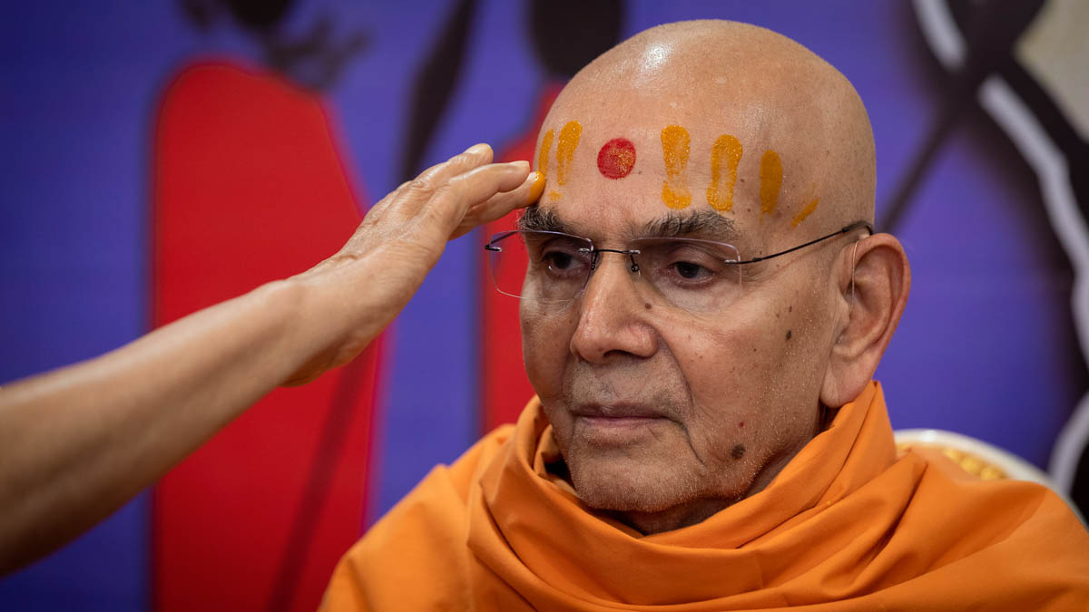 Pujya Tyagvallabh Swami applies chandan archa on Swamishri's forehead