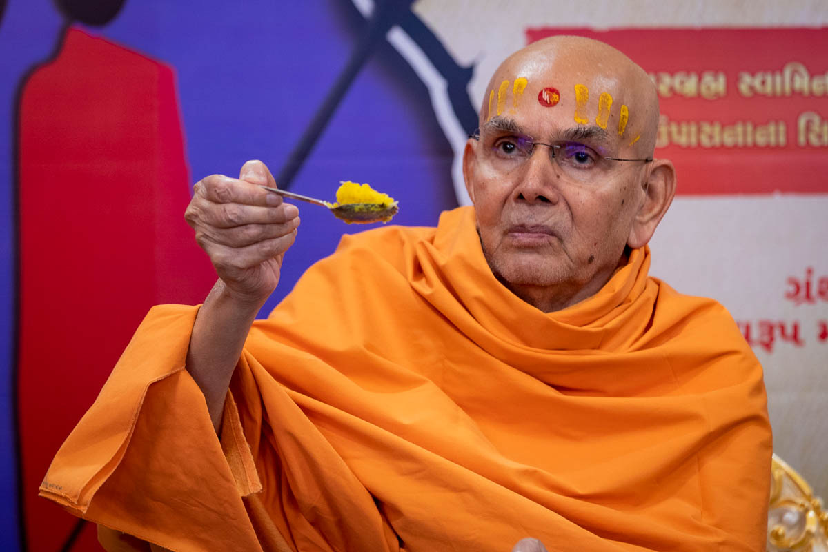 Swamishri gives prasad 