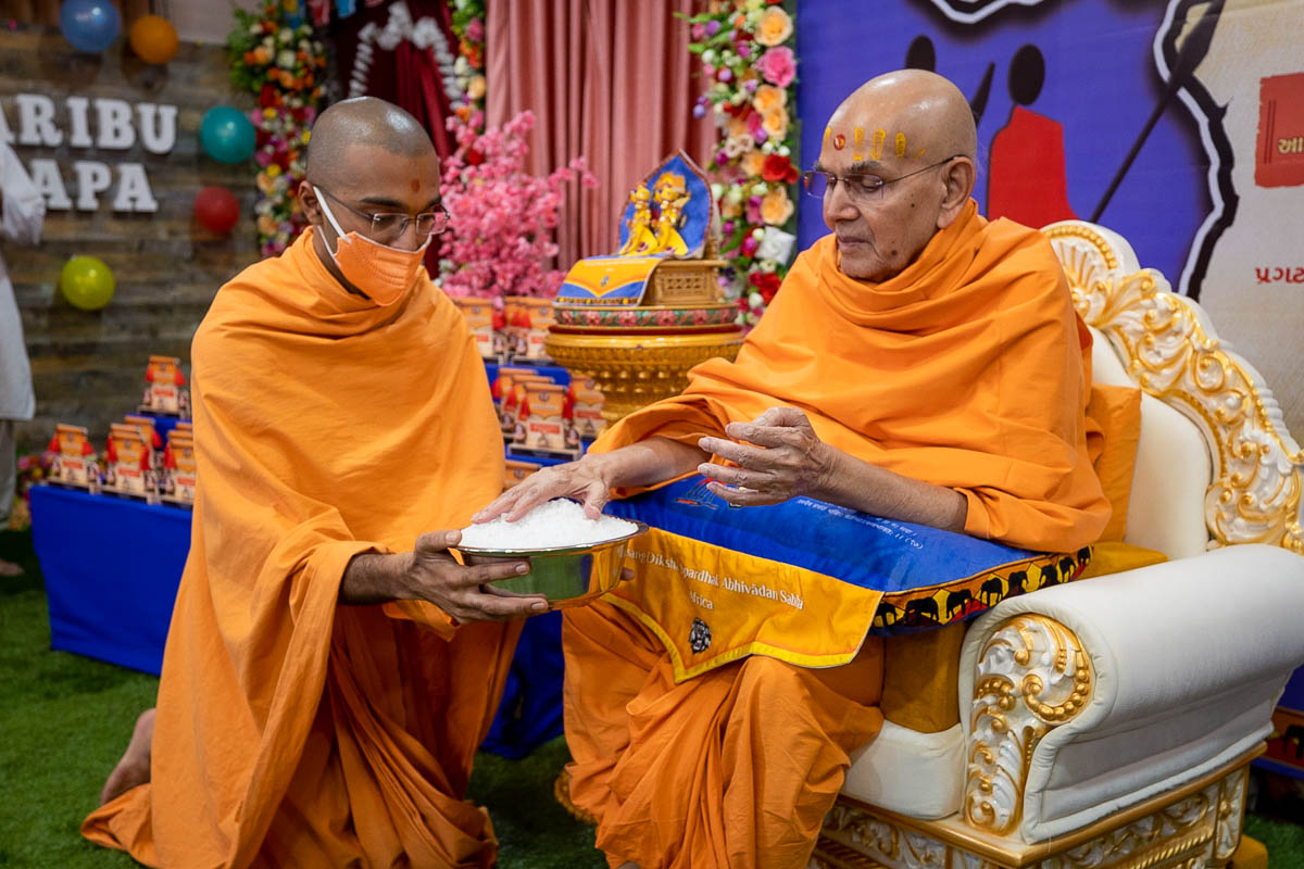 Swamishri sanctifies sugar crystals (prasad) for the participants