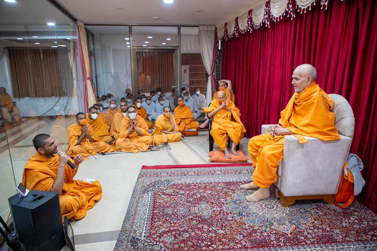 A sadhu presents before Swamishri during the afternoon assembly
