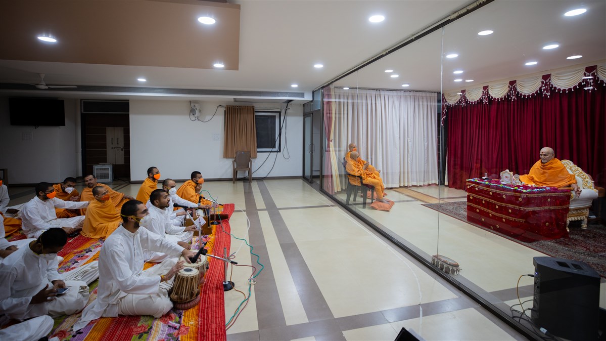 Sadhaks sing kirtans in Swamishri's daily puja
