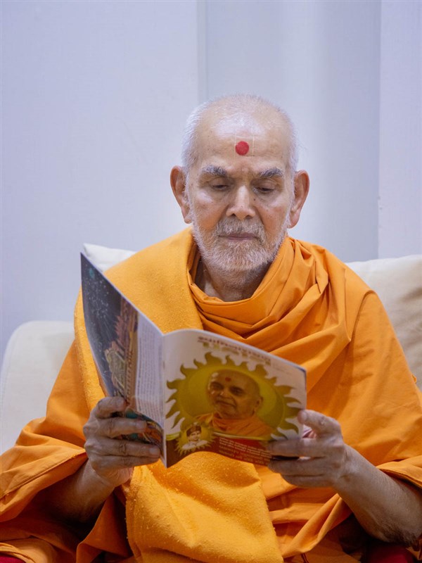 Swamishri reads the latest issue of 'Swaminarayan Prakash'