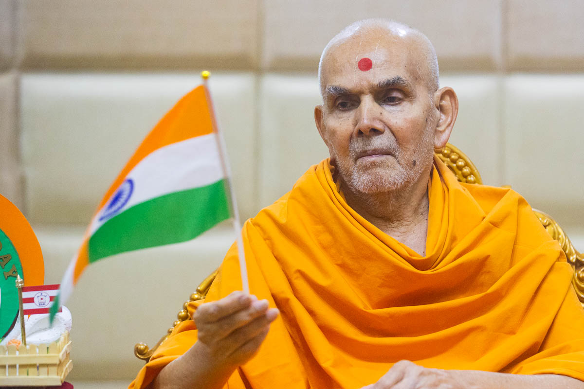 Swamishri waves an Indian flag to commemorate India's Republic Day