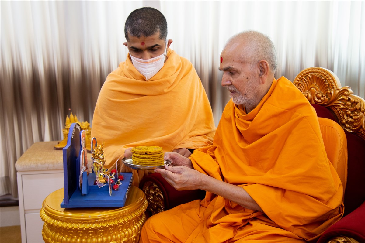 Swamishri offers puranpoli to Shri Harikrishna Maharaj and Shri Gunatitanand Swami