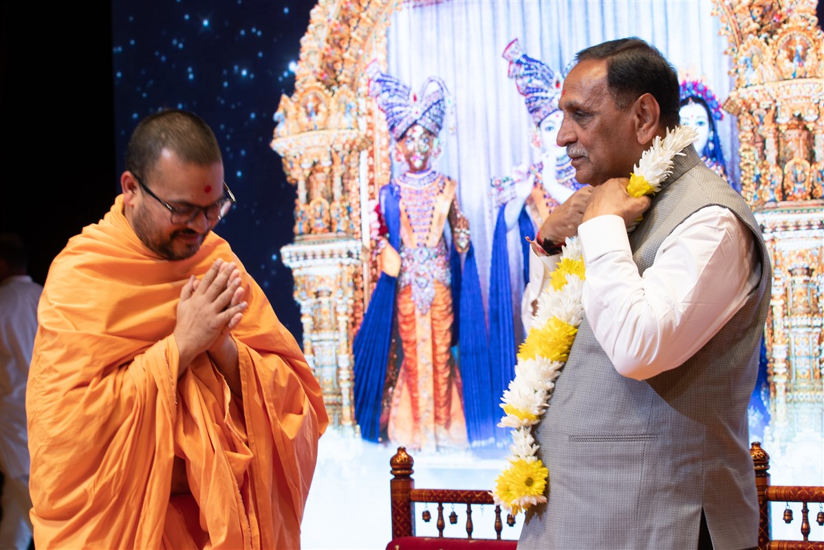 Pujya Divyacharandas Swami welcomes Shri Vijaybhai Rupani to the weekly spiritual assembly