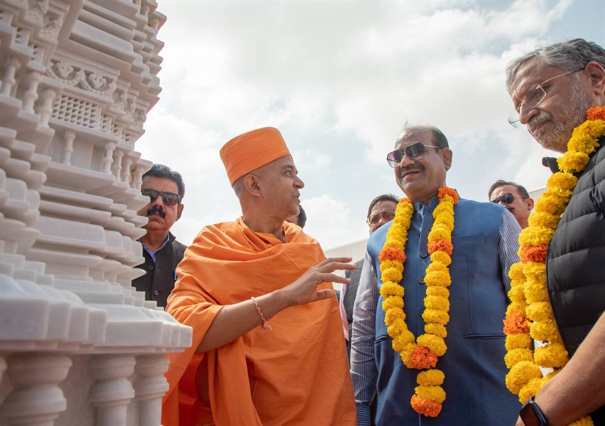 Brahmavihari Swami presents the intricate carvings of the front pillars of the mandir to Shri Om Birlaji, Sushil Kumar Modiji, and the delegation