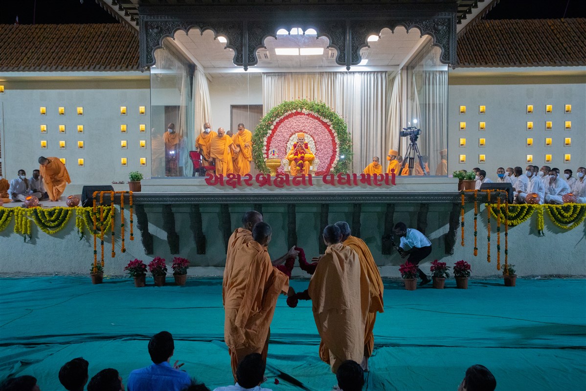 Sadhus from Surat honor Swamishri with a garland