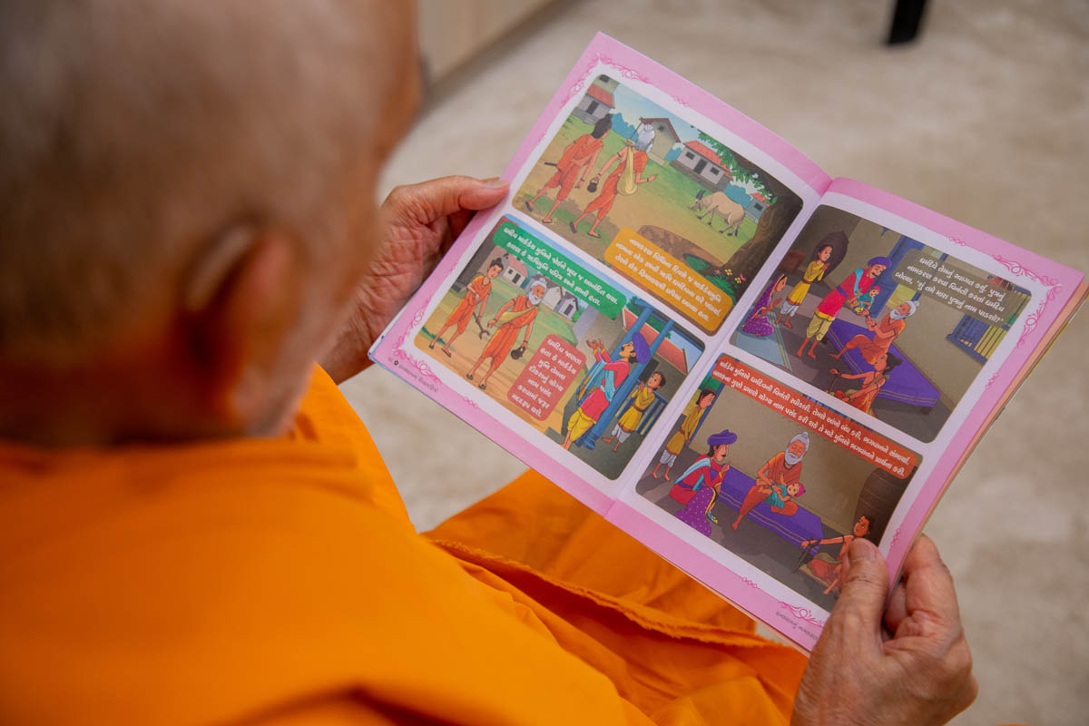 Swamishri reads the latest Gujarati issue of 'Swaminarayan Bal Prakash'