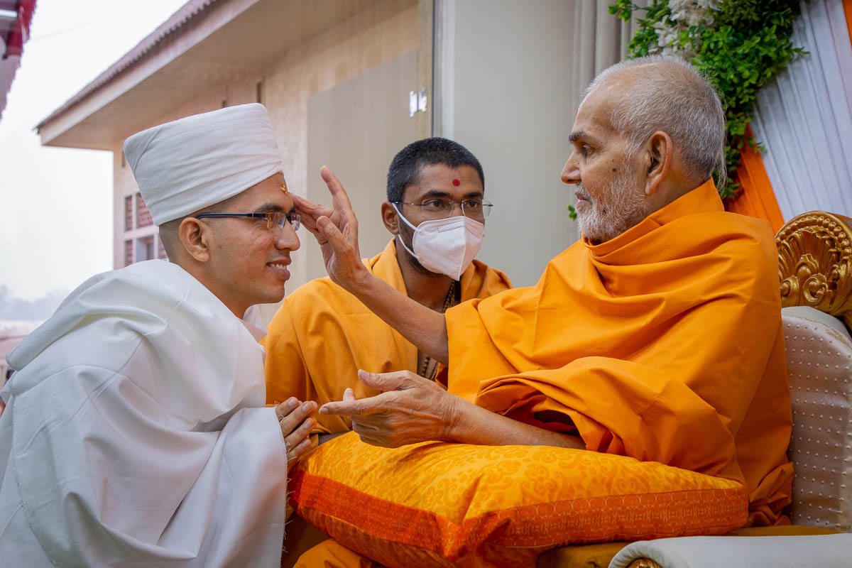 Swamishri gives diksha mantra and blessings to newly initiated parshad