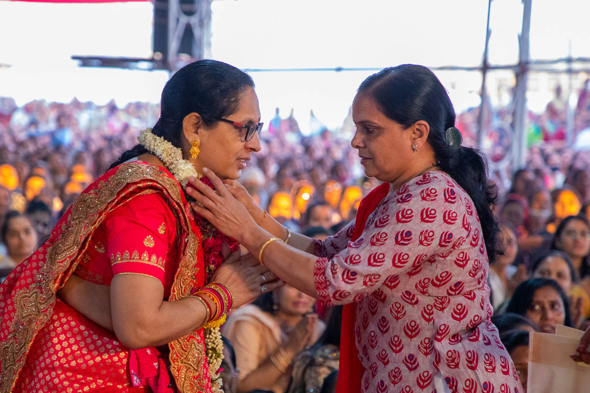 A karyakar honors the mother of the newly initiated parshad