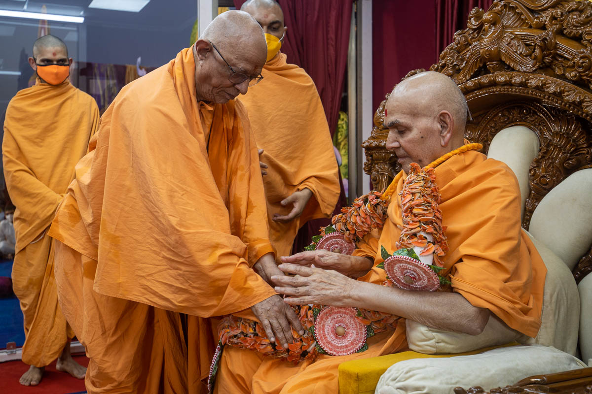 Pujya Doctor Swami honors Swamishri with a garland