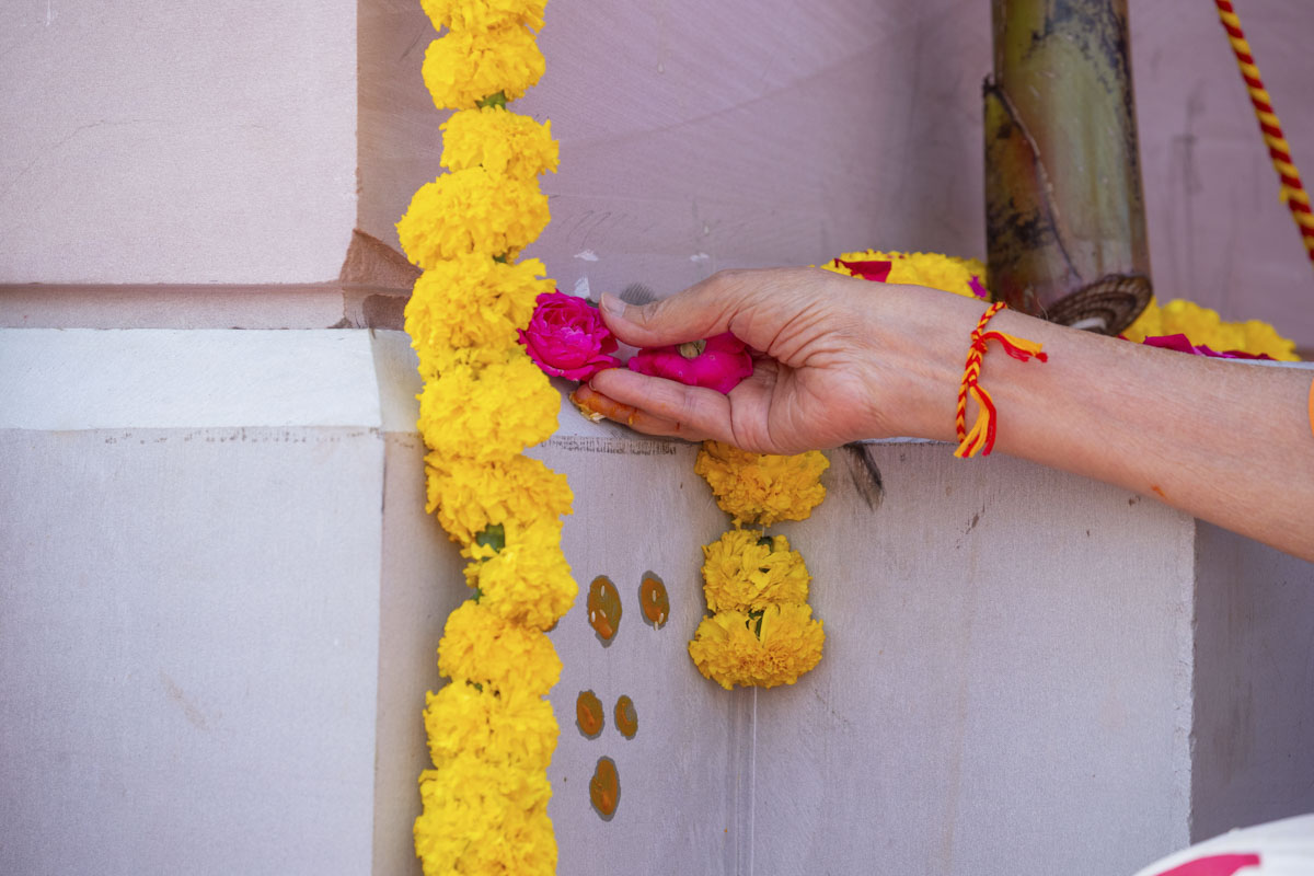 Swamishri places flowers on the pillar