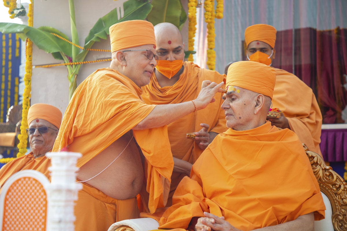 Pujya Ghanshyamcharan Swami  applies chandan archa on Swamishri's forehead