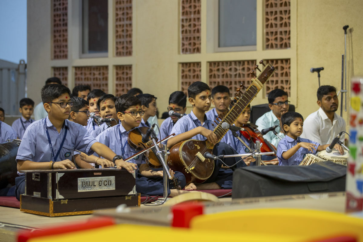 Students sing kirtans in Swamishri's daily puja