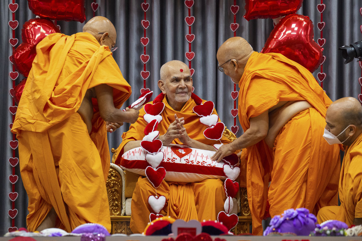 Pujya Tyagvallabh Swami and Pujya Ghanshyamcharan Swami honor Swamishri with a garland