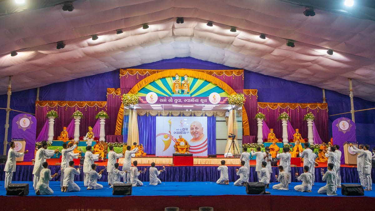 Swamishri and youths perform the evening arti