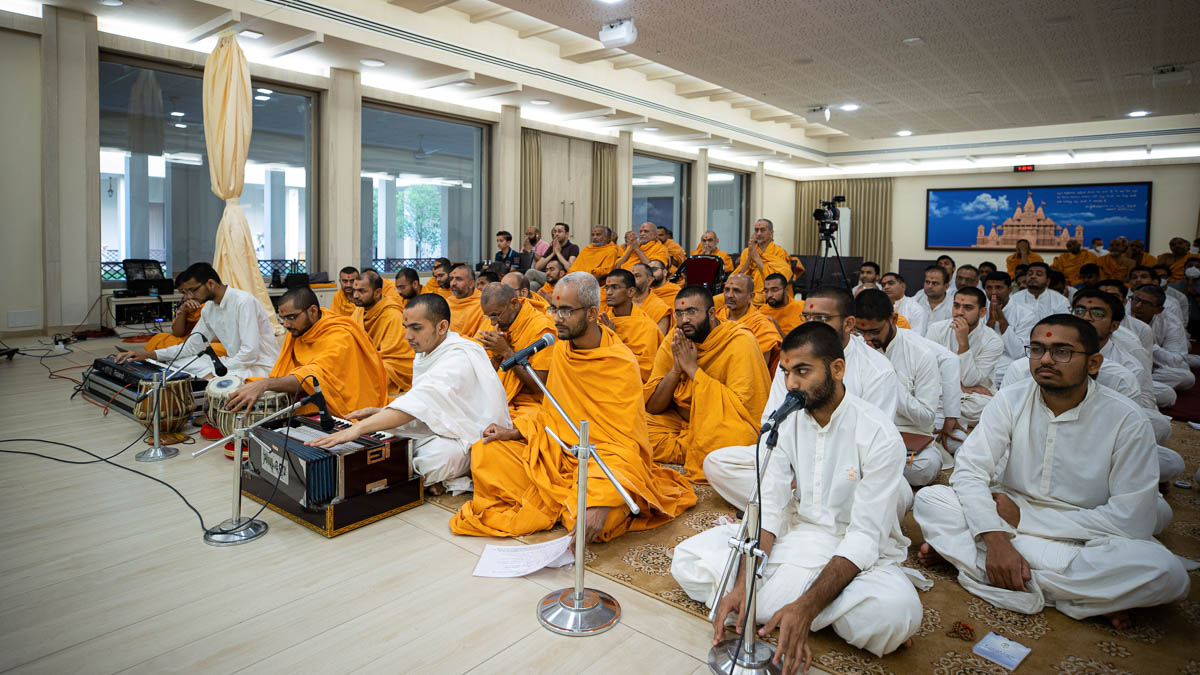 Sadhus and sadhaks sing kirtans during Swamishri's daily puja