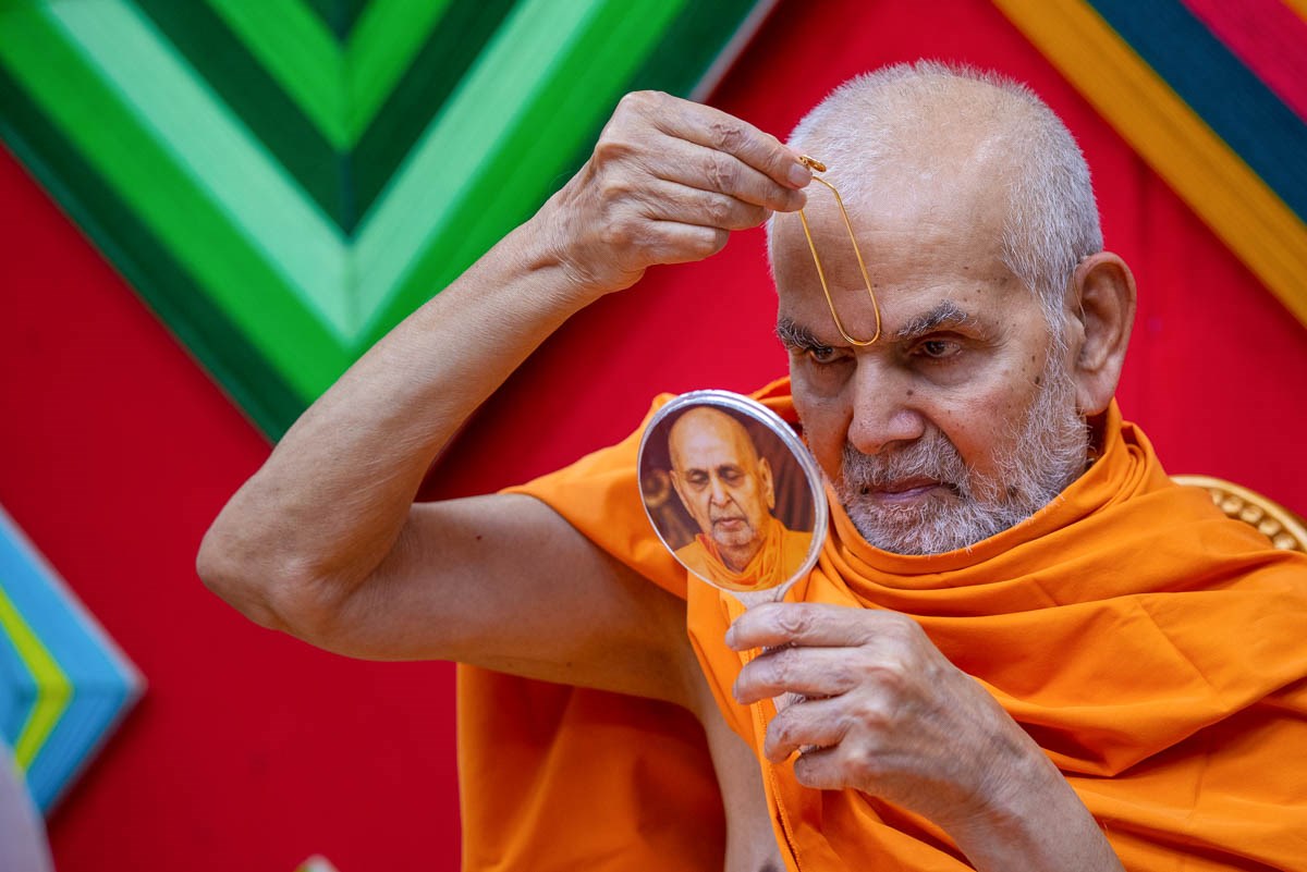 Param Pujya Mahant Swami Maharaj applies a tilak on his  forehead