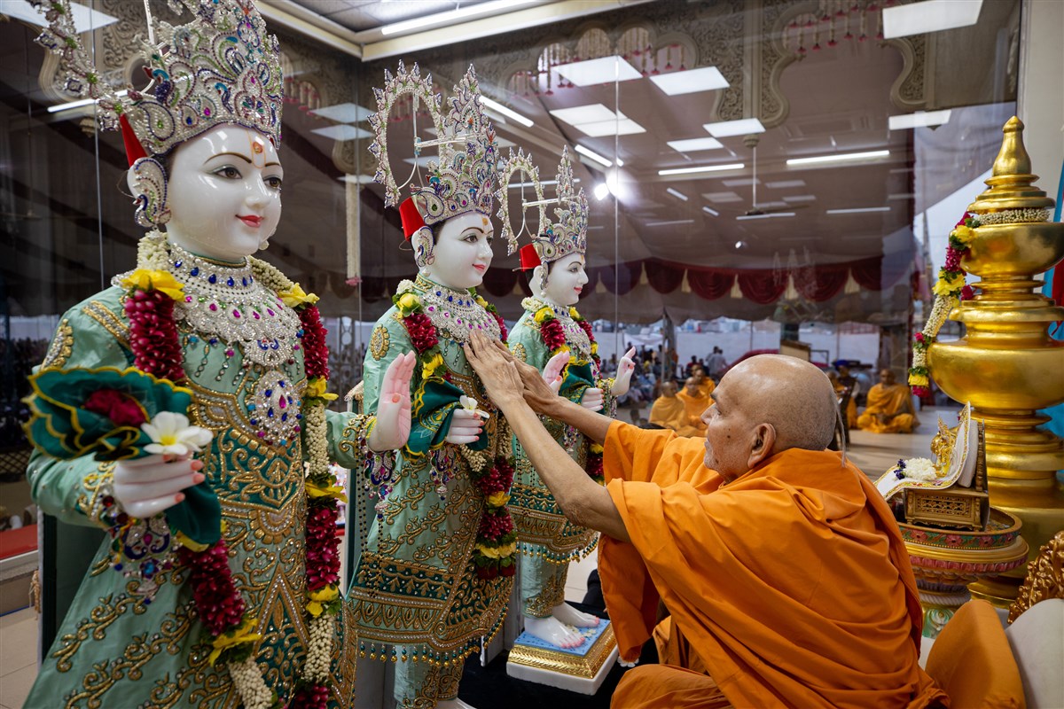 Swamishri performs the murti-pratishtha rituals in the evening assembly